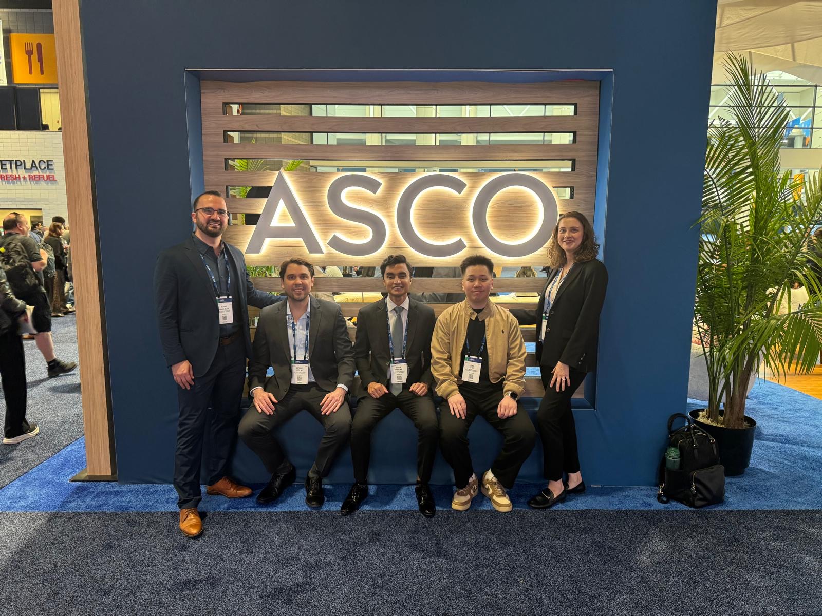 Group photo with colleagues in front of an ASCO sign